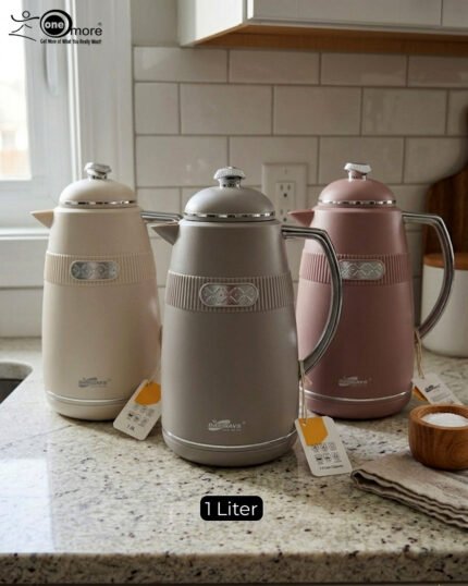 Three 1-liter DayDays thermal flasks in Dusty Rose, Warm Sand, and Stone Grey arranged on a granite kitchen countertop.