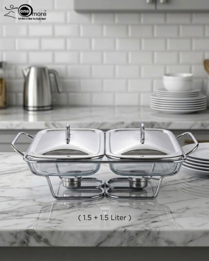 A Paramount Series 2-in-1 stainless steel food warmer with two 1.5-liter glass serving dishes and dual buffet burners, displayed on a marble kitchen countertop.