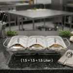 A professional Paramount Series 3-in-1 stainless steel food warmer with three 1.5L glass containers and polished metal lids, displayed on a kitchen counter and a dining table with various dishes.