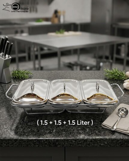 A professional Paramount Series 3-in-1 stainless steel food warmer with three 1.5L glass containers and polished metal lids, displayed on a kitchen counter and a dining table with various dishes.