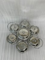 Paramount Series 7-in-1 buffet food warmer set featuring seven clear glass bowls with polished stainless steel lids and a silver metal stand with buffet burners on a decorated dining table.