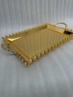 Add a touch of regal sophistication to your hosting with this exquisite 3-piece gold-plated stainless steel tray set. Featuring an intricate, laser-etched mandala design at the center and a decorative beaded "pearl" border, these trays blend traditional artistry with modern durability. The high-polish mirror finish reflects light beautifully, making them a stunning centerpiece for dining tables, coffee tables, or vanity displays. Whether you are serving refreshments to guests or organizing luxury accessories, this nesting set provides a versatile and opulent solution for any home. Key Features Premium Craftsmanship: Constructed from high-grade stainless steel with a brilliant gold-toned finish for long-lasting shine and rust resistance. Intricate Mandala Art: Each tray features a precision-etched geometric mandala pattern that adds a unique, artisanal feel to the collection. Ornate Beaded Edges: The scalloped rims are adorned with gold bead detailing, providing a secure grip and a sophisticated aesthetic. Versatile Set of Three: Includes small, medium, and large sizes that nest together for easy storage or can be used separately for multi-course serving. Multi-Purpose Decor: Ideal for serving appetizers, tea, and desserts, or used as a decorative base for candles, perfumes, and floral arrangements.