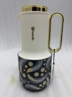 A trio of Feenik 1-liter luxury thermal flasks in cream with gold handles and lids, featuring three different artistic patterns on the base, displayed on a white marble kitchen counter.