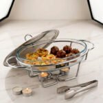 Three Paramount Series glass and stainless steel food warmers in 1.5L, 2L, and 3L sizes arranged on a dining table with tea light candles lit underneath.