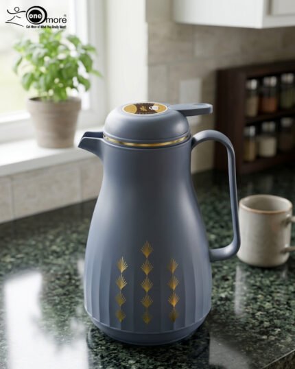 Two elegant 1-liter thermal carafes in matte black and slate blue with gold decorative patterns, displayed on a kitchen counter next to a coffee machine.