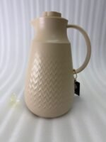 A 1-liter insulated thermal flask with a 3D diamond-patterned matte body, featuring a curved handle and a spout, shown in black and beige color options on a kitchen countertop.