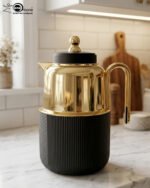 Three luxury 1-liter thermal flasks in white, grey, and black with polished gold tops and ribbed textured bases on a marble kitchen counter.