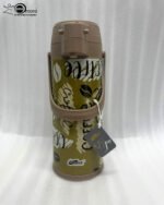 A 1.9-liter olive green Day Days vacuum insulated coffee airpot with a brown pump-action lid and handle, featuring a decorative coffee bean pattern, displayed on a kitchen counter next to a coffee cup.