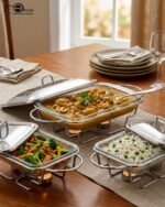 Three elegant Paramount Series food warmers in different sizes (1.5L, 2.4L, and 3L) featuring stainless steel lids and glass dishes with candle-lit buffet burners on a dining table.