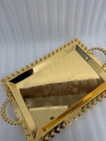 Add a touch of regal sophistication to your hosting with this exquisite 3-piece gold-plated stainless steel tray set. Featuring an intricate, laser-etched mandala design at the center and a decorative beaded "pearl" border, these trays blend traditional artistry with modern durability. The high-polish mirror finish reflects light beautifully, making them a stunning centerpiece for dining tables, coffee tables, or vanity displays. Whether you are serving refreshments to guests or organizing luxury accessories, this nesting set provides a versatile and opulent solution for any home. Key Features Premium Craftsmanship: Constructed from high-grade stainless steel with a brilliant gold-toned finish for long-lasting shine and rust resistance. Intricate Mandala Art: Each tray features a precision-etched geometric mandala pattern that adds a unique, artisanal feel to the collection. Ornate Beaded Edges: The scalloped rims are adorned with gold bead detailing, providing a secure grip and a sophisticated aesthetic. Versatile Set of Three: Includes small, medium, and large sizes that nest together for easy storage or can be used separately for multi-course serving. Multi-Purpose Decor: Ideal for serving appetizers, tea, and desserts, or used as a decorative base for candles, perfumes, and floral arrangements.