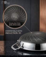 High-angle shot of two Uakeen stainless steel non-stick woks in 30cm and 32cm sizes on a wooden countertop, showing the laser-etched hexagonal interior and tempered glass lids.