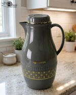 A trio of elegant 2-liter Feenik thermal flasks in cream, grey, and taupe featuring gold floral patterns on a marble kitchen countertop.