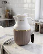 Three 1-liter Feenik thermal flasks in charcoal, taupe, and gray colors with gold trim on a marble kitchen countertop.