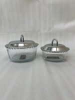 Paramount Series 7-in-1 buffet food warmer set featuring seven clear glass bowls with polished stainless steel lids and a silver metal stand with buffet burners on a decorated dining table.