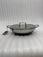 High-angle shot of two Uakeen stainless steel non-stick woks in 30cm and 32cm sizes on a wooden countertop, showing the laser-etched hexagonal interior and tempered glass lids.