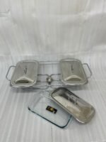 A professional Paramount Series 3-in-1 stainless steel food warmer with three 1.5L glass containers and polished metal lids, displayed on a kitchen counter and a dining table with various dishes.