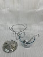 A 4-liter Paramount Series food warmer featuring a clear glass bowl, stainless steel stand, and lid, shown on a dining table with guests and filled with warm lentil soup.