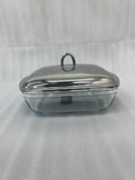 A luxurious Paramount Series 5-in-1 food warmer set on a wooden dining table, featuring four 2.5L glass serving dishes with polished stainless steel lids and tealight buffet burners underneath.