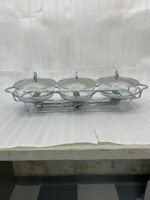 Three-section stainless steel food warmer from the Paramount Series featuring three 1.5L glass bowls with metal lids on a silver wire rack with tea light candle burners underneath.