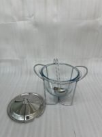 A 4-liter Paramount Series food warmer featuring a clear glass bowl, stainless steel stand, and lid, shown on a dining table with guests and filled with warm lentil soup.