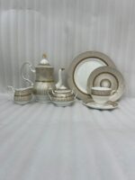 A premium super bone china tea set featuring a teapot, teacup and saucer, creamer, and sugar bowl with elegant beige striped patterns and luxury gold accents on a wooden table.