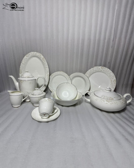A comprehensive collection of 61 pieces of white bone china dinnerware featuring an intricate gold and cream floral pattern with gold rims, arranged elegantly on a wooden table.