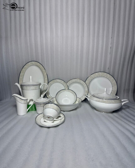 An elegant 61-piece white super bone china dinner set arranged on a polished wooden table against a neutral beige wall. The porcelain tableware features sophisticated silver-grey textured borders and includes dinner plates, bowls, a large oval serving platter, a covered soup tureen, and a complete tea service with a teapot, creamer, sugar bowl, cups, and saucers