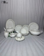 Elegant 61-piece super bone china dinner set by OneMore with an intricate silver lace border design, beautifully arranged on a wooden table against a plain background, including plates, bowls, a teapot, and a soup tureen
