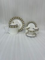 A complete 24-piece luxury porcelain tea set featuring a modern olive green and black striped pattern with gold accents, displayed on a wooden surface