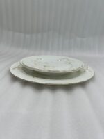 A stacked 18-piece super bone china plate set from Onemore Crockery featuring floral patterns and gold rims, displayed on a wooden table.