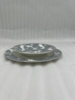 A stacked 18-piece super bone china dinnerware set featuring a grey and white floral pattern on a wooden table, including rice, deep, and quarter plates.