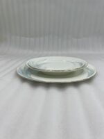 A stacked 18-piece white super bone china plate set on a wooden dining table, featuring 6 rice plates, 6 deep plates, and 6 quarter plates with a subtle design