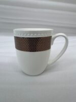 A set of six elegant white bone china mugs with a decorative rose-gold geometric band and beaded rim, displayed on a wooden tray with hot tea and rising steam in a warm, cinematic library setting