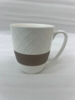 A set of six premium white ceramic tea mugs with a textured lattice design and a brown patterned base, filled with steaming tea and placed on a wooden outdoor table next to a silver spoon