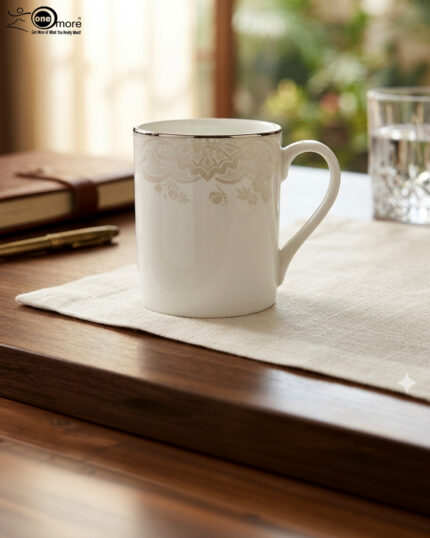 A set of two white bone china mugs on a wooden surface, one short and one tall, featuring elegant gold lace patterns and metallic gold rims against a neutral background.