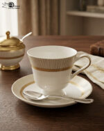 A luxury super bone china dinner set featuring a white base with gold-toned textured borders and metallic accents, displayed on a wooden table in 7.jpg.