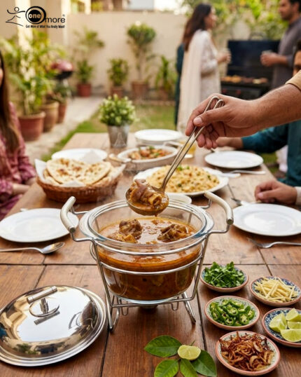 Paramount Series 4-liter glass food warmer with a stainless steel stand, lid, and ladle, featuring a buffet burner holder on a wooden dining table.