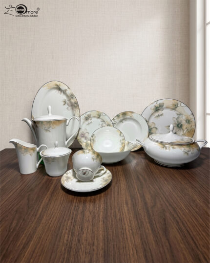 A premium 61-piece white super bone china dinner set with a delicate green and gold floral pattern displayed on a polished dark wood table. The set features an elegant teapot, casserole tureen, serving bowls, large oval platter, dinner plates, side plates, and tea cups with saucers against a neutral textured background