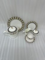 A complete 24-piece luxury porcelain tea set featuring a modern olive green and black striped pattern with gold accents, displayed on a wooden surface