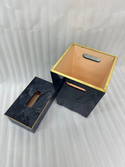 A luxury blue marble resin tissue box cover and matching wastebasket with elegant gold trim on dark wooden tables in a bathroom setting.