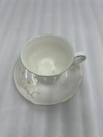 Elegant white Super Bone China cup and saucer set featuring a delicate white floral pattern and a luxurious gold-painted rim, displayed against a clean white background