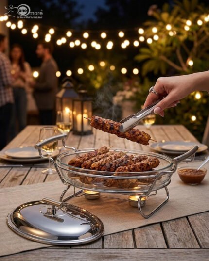 Two Paramount Series stainless steel oval food warmers in 2.4L and 3L sizes on a table runner, featuring glass bowls and polished metal lids.