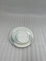 A stacked 18-piece white super bone china plate set on a wooden dining table, featuring 6 rice plates, 6 deep plates, and 6 quarter plates with a subtle design