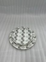 Stacked 18-piece super bone china plate set with grey floral patterns, including rice plates, deep plates, and quarter plates on a wooden dining table.