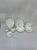 A luxurious white Super Bone China dinner set featuring delicate grey leaf patterns and gold-rimmed detailing, including plates, bowls, a teapot, and a tureen.