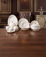 A luxurious white Super Bone China dinner set featuring delicate grey leaf patterns and gold-rimmed detailing, including plates, bowls, a teapot, and a tureen.