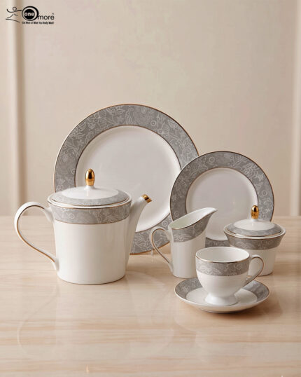A 24-piece luxury porcelain tea set featuring a crisp white finish, sophisticated grey floral patterned rims, and delicate gold accents, arranged on a glossy surface.