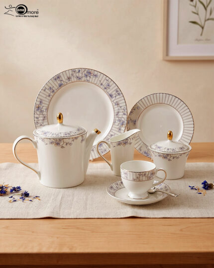 A 24-piece luxury porcelain tea set featuring a delicate blue floral pattern, gold accents, and striped borders, arranged elegantly on a linen runner.