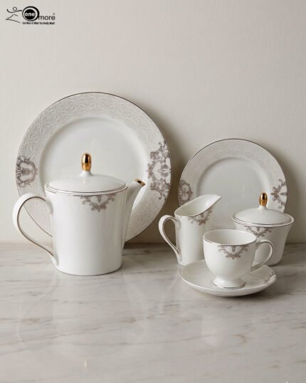 A complete 24-piece porcelain tea set featuring a teapot, sugar bowl, milk jug, tea cups, saucers, and plates, all decorated with intricate grey filigree patterns and gold accents, displayed on a marble surface.