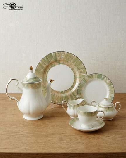 A 24-piece luxury porcelain tea set featuring white dishes with soft green, brush-stroke patterned edges and delicate gold rims, displayed on a wooden surface.